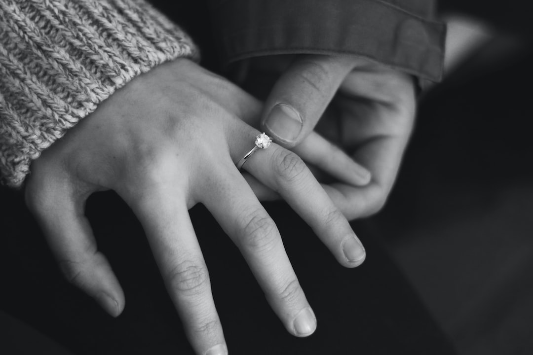 woman wearing wedding ring with man holding hand