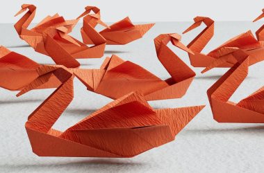 a group of orange origami swans sitting on top of a table
