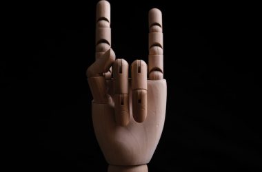 a wooden sculpture of a hand making a peace sign