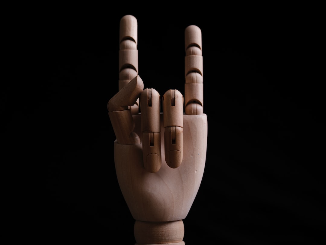 a wooden sculpture of a hand making a peace sign