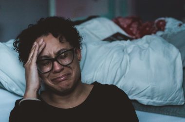 person crying beside bed