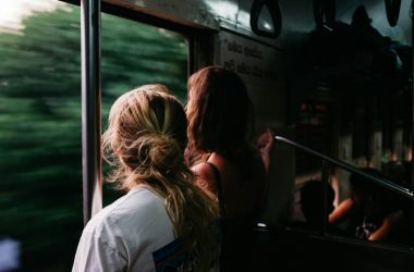 two person standing on train window
