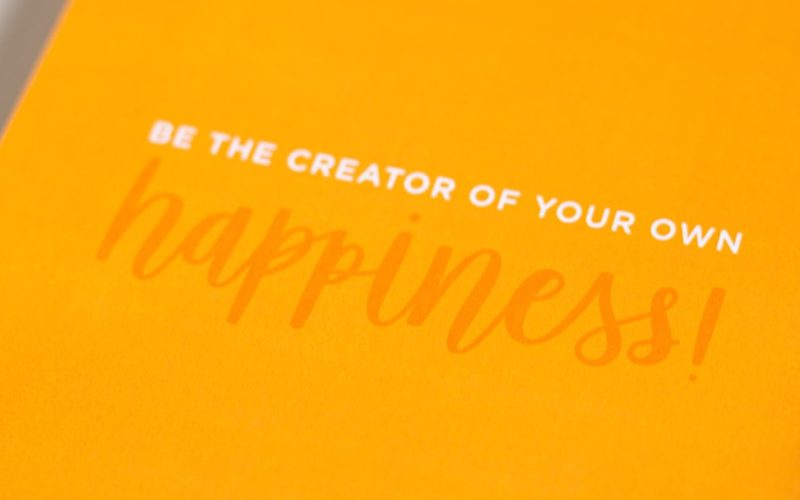 a yellow greeting card with the words be the creator of your own happiness