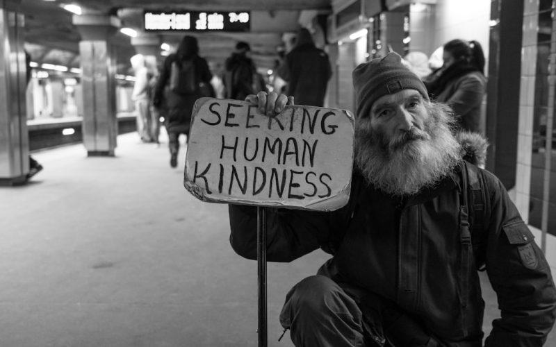 man holding card with seeking human kindness text