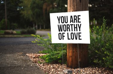 you are worthy of love sign beside tree and road