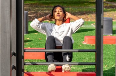 woman in white long sleeve shirt and black pants sitting on red metal frame