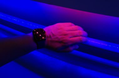 a person's hand holding onto a blue light