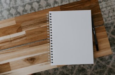 white spiral notebook on brown wooden table