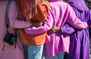 four person holding each others waist at daytime