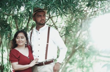 a man standing next to a woman under a tree