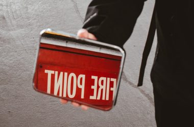 person holding red and white stop sign