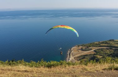 a paraglider is flying over a body of water