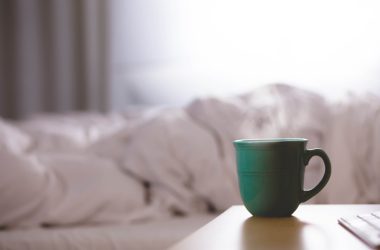 green ceramic mug on wooden desk