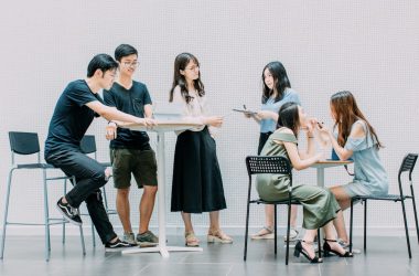 two men and four women meeting in office