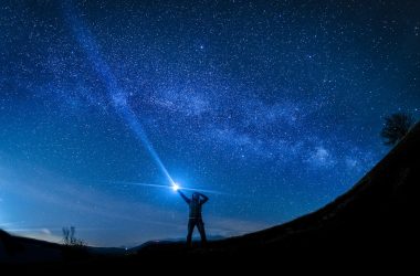 silhouette of man holding flashlight