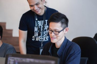 man standing behind sitting man