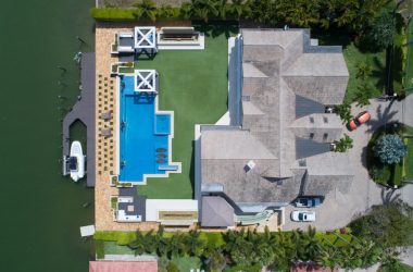 bird's eye view of house with pool near body of water