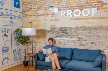 man sitting on blue sofa while reading book