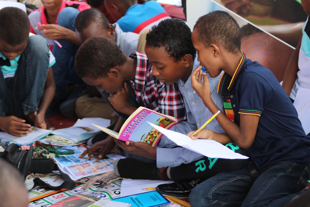 boy in blue and white plaid shirt reading book