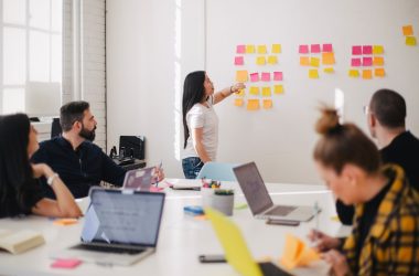 woman placing sticky notes on wall