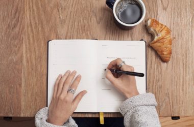 person writing on a book