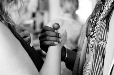 grayscale photo of man and woman holding their hands