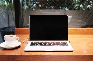 laptop computer beside coffee mug