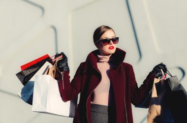 photo of woman holding white and black paper bags