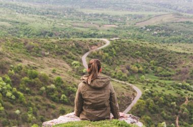 woman sitting on grey cliff