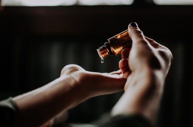 person holding amber glass bottle