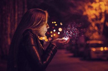 woman blowing sprinkle in her hand