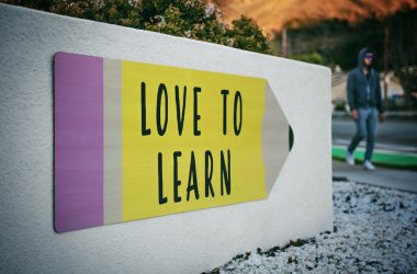 love to learn pencil signage on wall near walking man