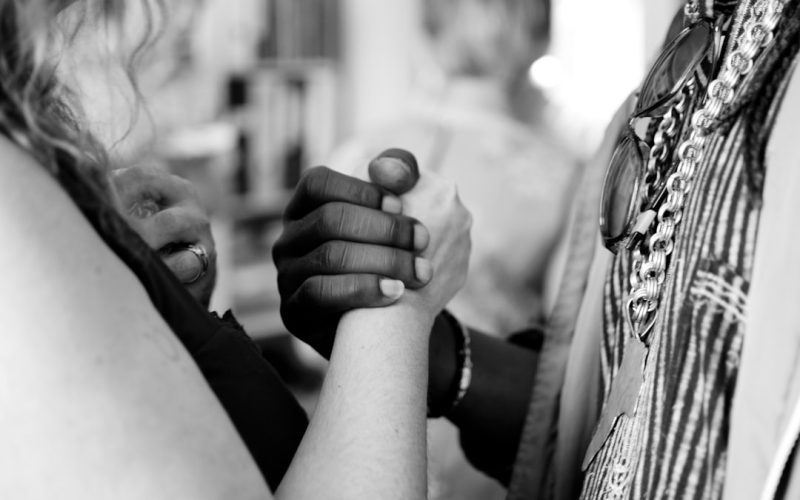 grayscale photo of man and woman holding their hands