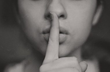 grayscale photo of woman doing silent hand sign