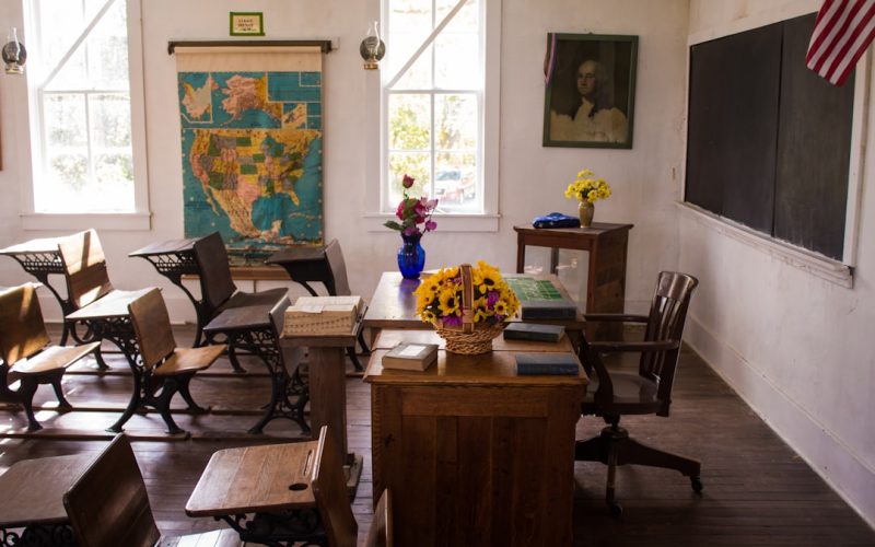 vacant white painted classroom with chairs, tables , and map on the wall