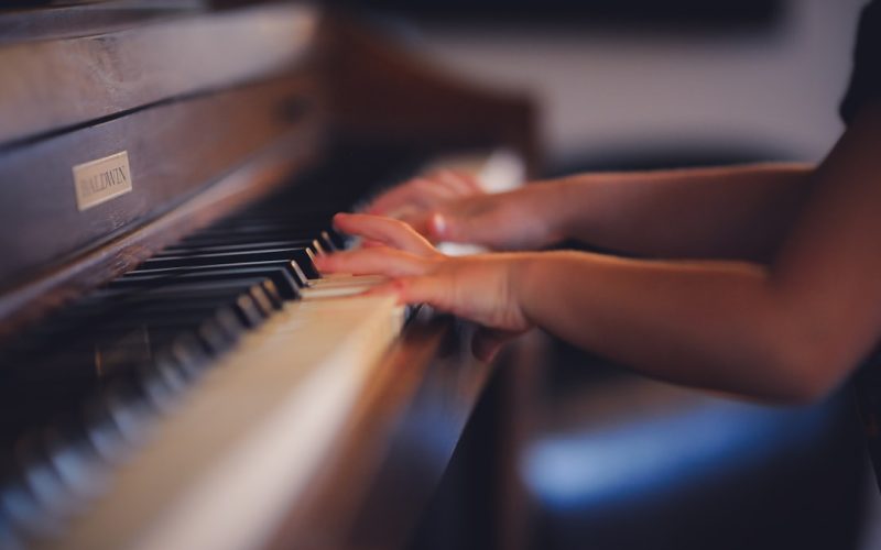 person playing upright piano