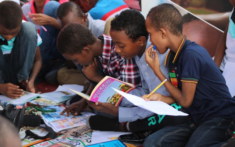 boy in blue and white plaid shirt reading book