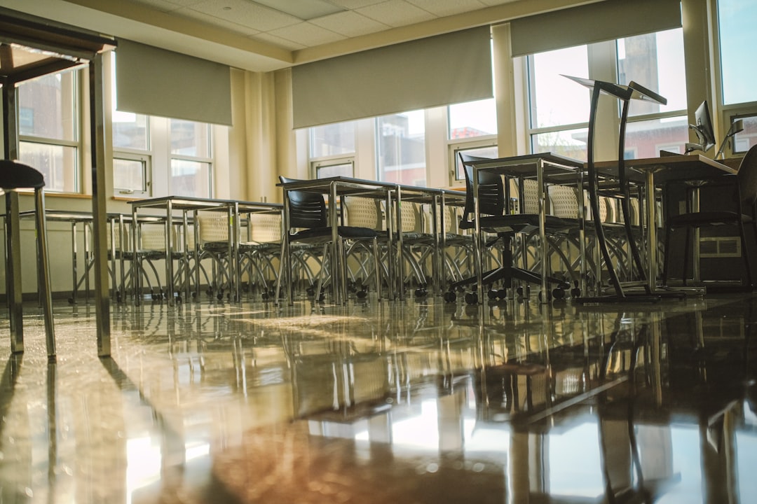 An empty classroom with tables and chairs.