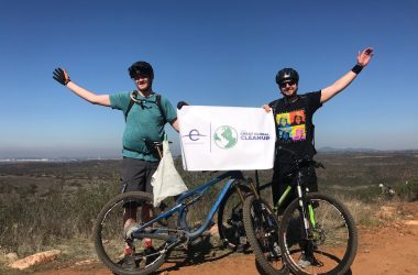 man in green shirt and black pants riding blue mountain bike
