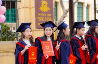 a group of girls in graduation gowns holding diplomas