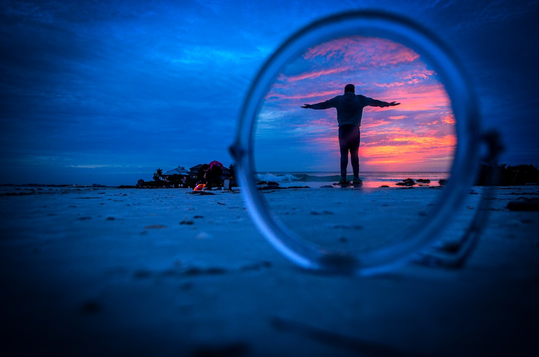a man standing on a beach with his arms outstretched
