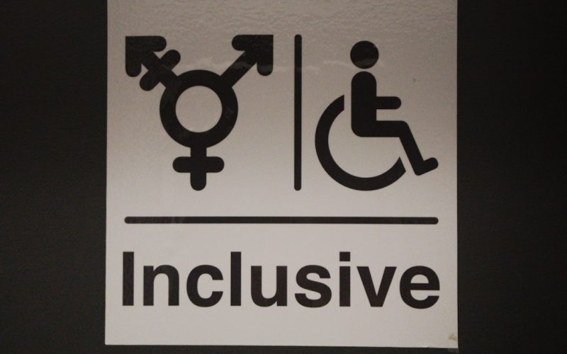 A white sign with a black and white image of a person in a wheelchair