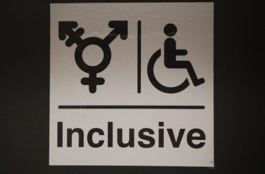 A white sign with a black and white image of a person in a wheelchair