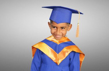 a young boy in a blue graduation gown
