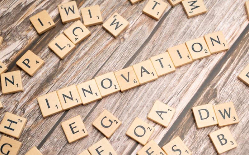 scrabble tiles spelling the word innovation on a wooden surface