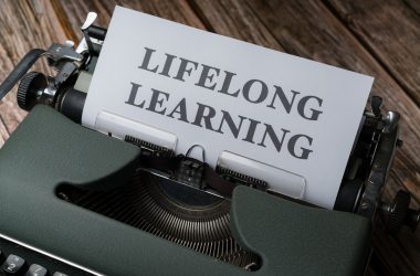 a close up of a typewriter with a paper that says lifelong learning