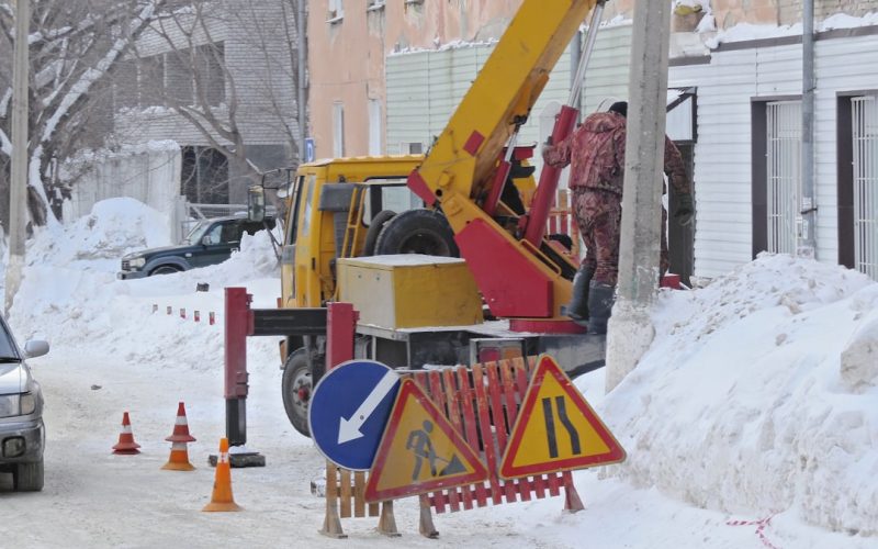 yellow and black excavator on snow covered ground during daytime
