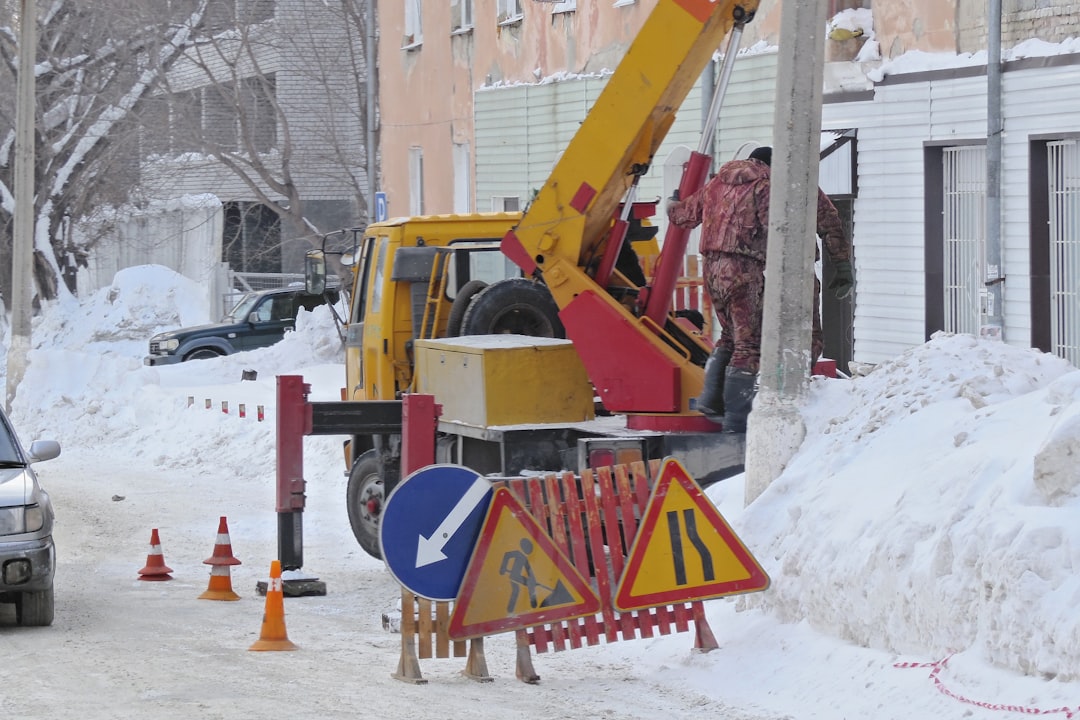 yellow and black excavator on snow covered ground during daytime
