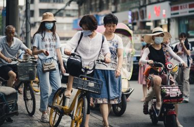 woman in white shirt and blue denim skirt riding on motorcycle during daytime