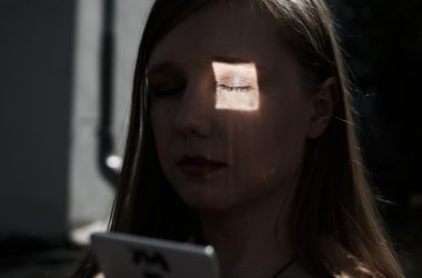a woman with her eyes closed looking at a tablet